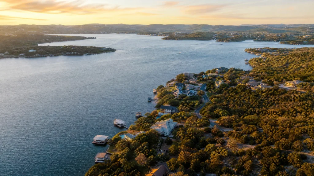 Aerial view of lakefront homes and boat docks along the Highland Lakes shoreline near Marble Falls, Texas at sunset